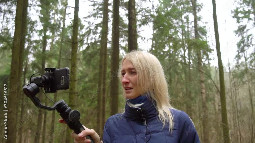 Woman blogger makes video with her phone and gimbal in the forest on  nature. She cries and upset tells her viewers and followers on Instagram  and YouTube. Stock Video | Adobe Stock