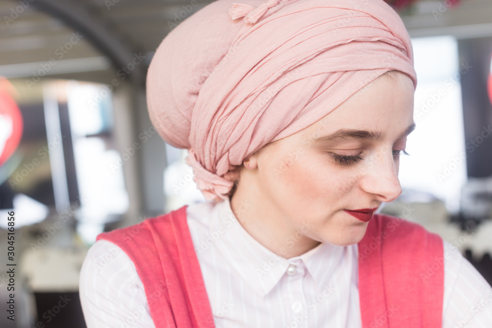 Close up portrait of blue eyed young European Muslim woman with hijab . Romantic portrait of woman wearing pastel pink turban/scarf. Close up portrait of blue eyed young European Muslim woman with hijab . Romantic portrait of woman wearing pastel pink turban/scarf.