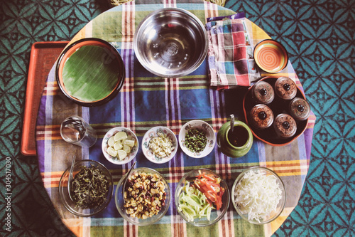 Ingredients for Myanmar Burmese traditional leaf salad and table set up close up