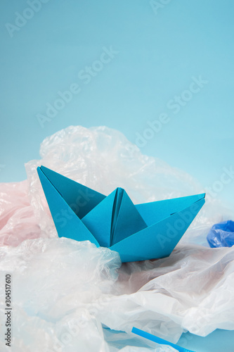 Ecology. The problem of pollution and debris in the ocean. Paper boats on plastic bags. Zero waste concept.