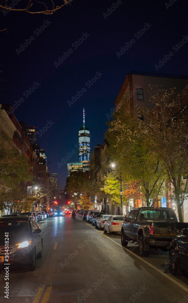 Night view of W Broadway street in Soho, with the One World Tower on the background. Midtown New York.
