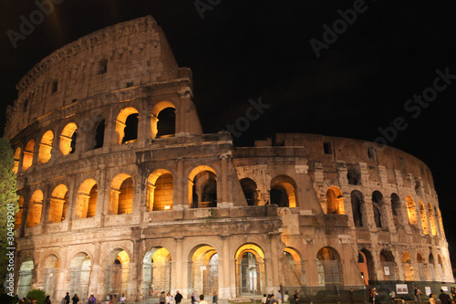 Colosseum in rome at night with illuminated arches 