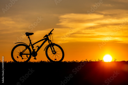 Mountain bike on the hillside at sunset.