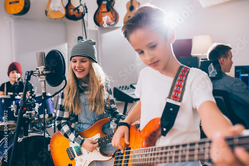 Fotografie kids rock band playing instruments in music studio