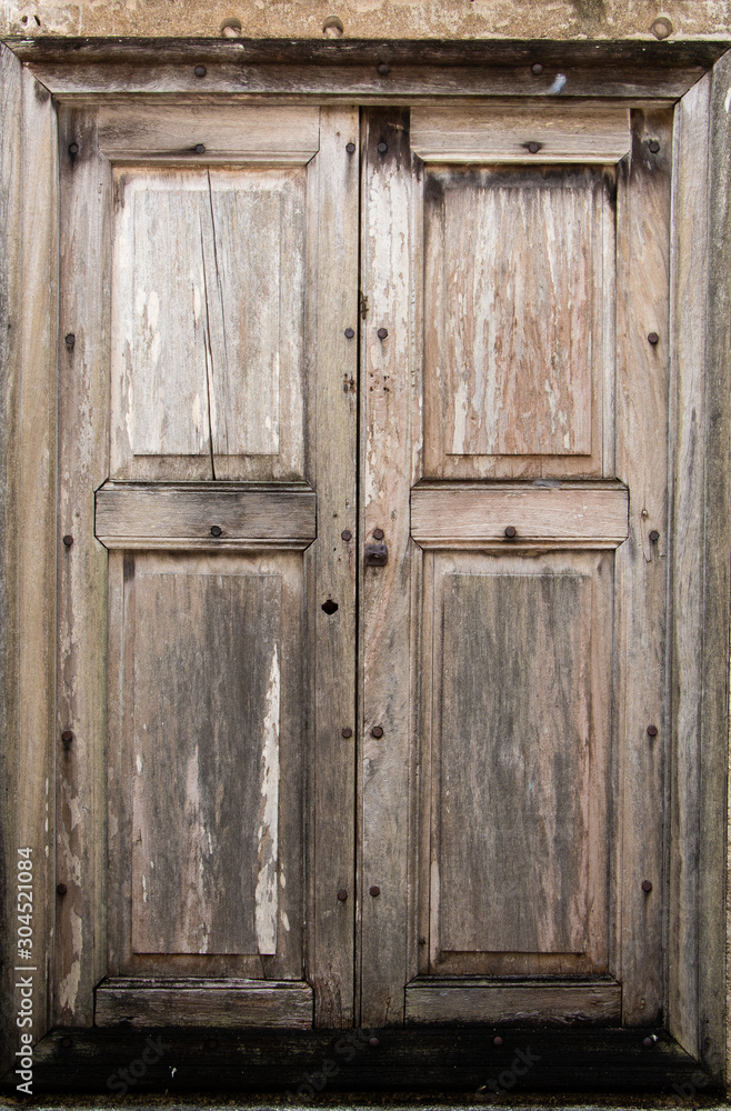 Old wooden window with Wood color shutters on weathered wall. Old wooden window with Wood color shutters on weathered wall.
