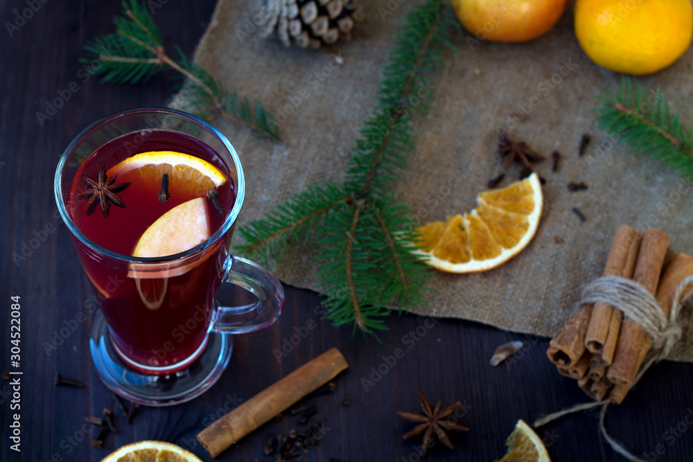 mulled wine with slices of orange, apple and spices, cinnamon and anise star on a wooden table with winter decorations. hot drinks of winter and autumn. copy space. top view mulled wine with slices of orange, apple and spices, cinnamon and anise star on a wooden table with winter decorations. hot drinks of winter and autumn. copy space. top view