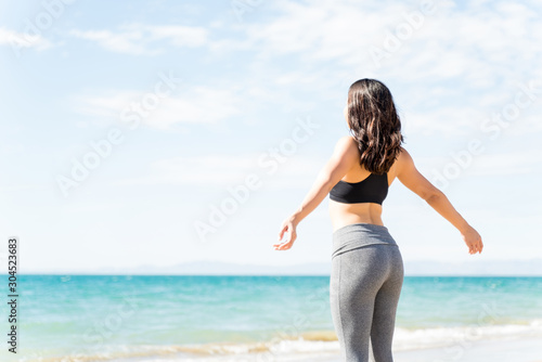 Fototapeta Naklejka Na Ścianę i Meble -  Young Athlete In Sportswear Standing At Beach