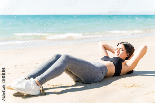 Fit Woman Doing Abs Workout At Beach