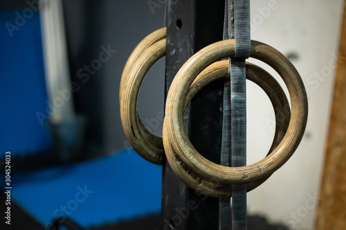 Gymnastic rings at the crossfit gym. Close up photo, blurred background. 