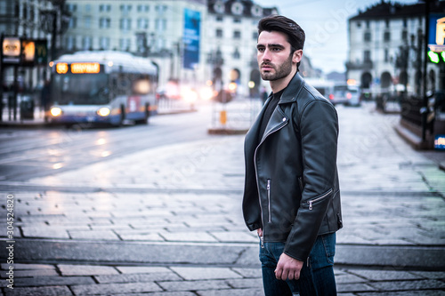 Slika na platnu One handsome young man in urban setting in modern city, standing, wearing black