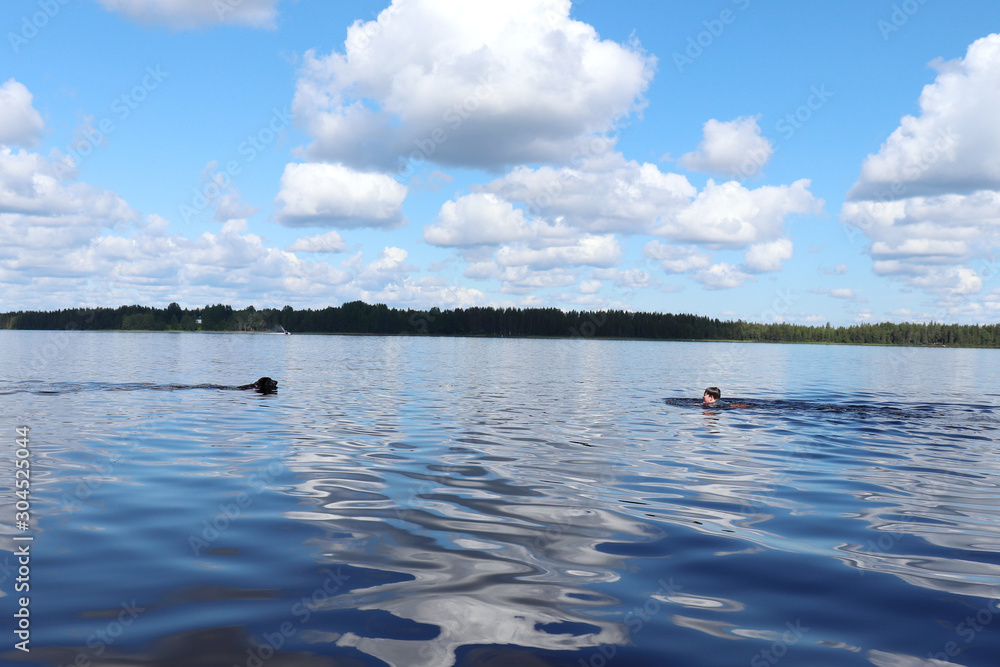 Boy and dog swimming in Lake Ranuanjarvi in Finland