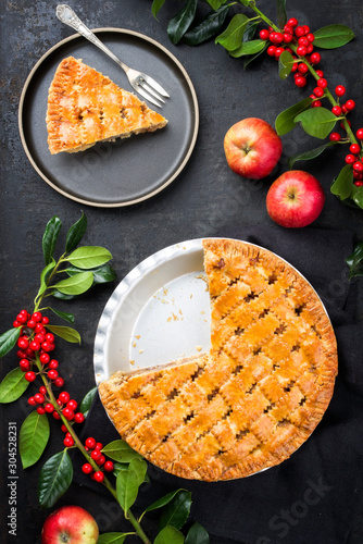 Traditional apple jalousie cake offered as top viewon modern design plate and backing form with decoration on a black board photo