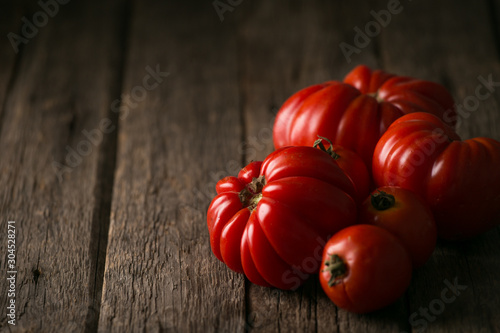 Fresh, ripe tomatoes on wood background.