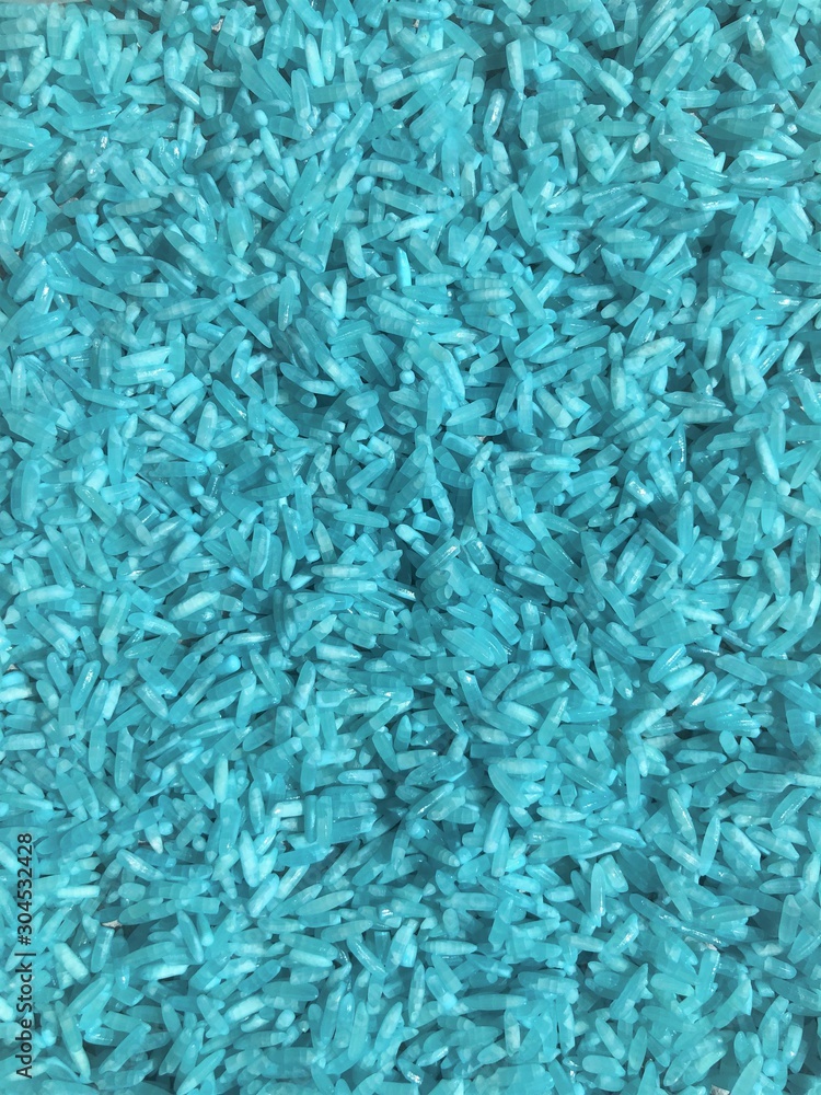 Rice background with granular details, texture. Blue raw uncooked rice close up shot. Rice background with granular details, texture. Blue raw uncooked rice close up shot.
