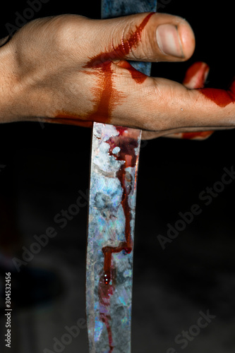 a sharp broken piece of glass dip into a hand and bleeding 