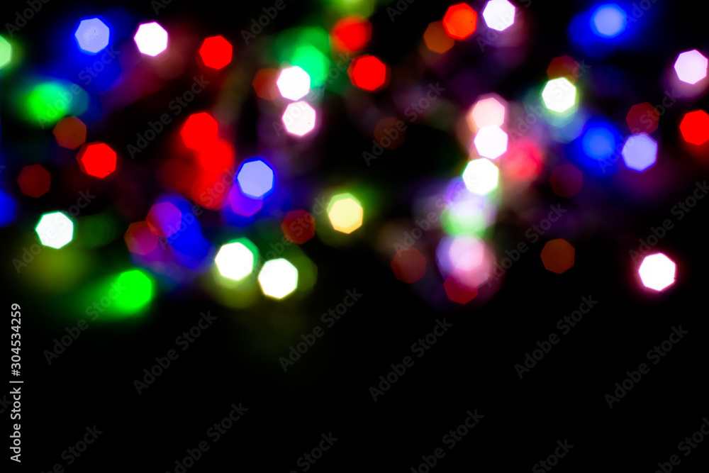 Christmas lights are lit on a black background. Copy the area for the top view text.