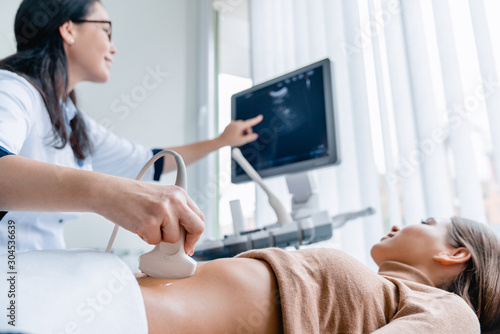 Mid adult female doctor using ultrasound scanner