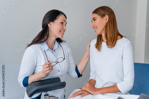 Young woman patient with gynecologist during consultation in doctor's office photo