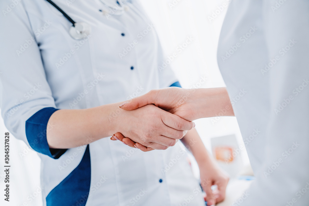 Close up of woman doctor shaking hands with patient Close up of woman doctor shaking hands with patient