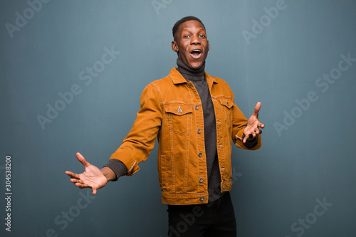 young african american black man performing opera or singing at a concert or show, feeling romantic, artistic and passionate against grunge wall photo