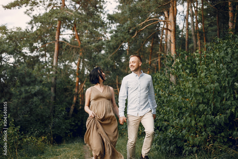 Pragnant woman. Family in a field. Man in a white shirt