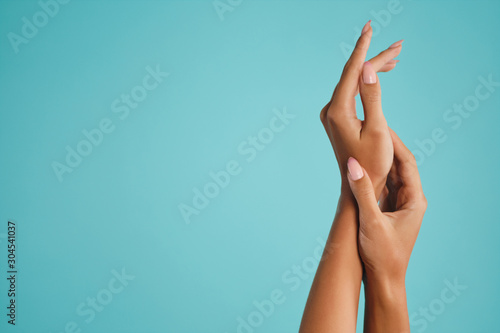 Close up beautiful female hands over blue background isolated