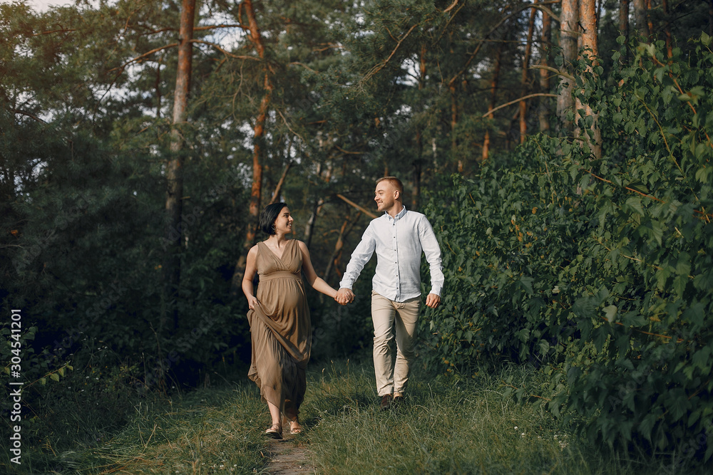 Pragnant woman. Family in a field. Man in a white shirt Pragnant woman. Family in a field. Man in a white shirt