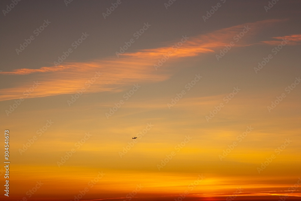 sunset in the sky with plane