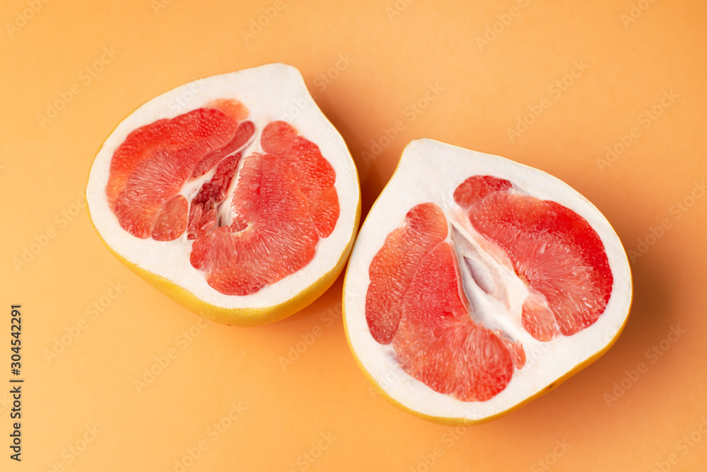 Fresh grapefruit on an orange background, close-up. Sex concept. The concept of women's health. Fresh grapefruit on an orange background, close-up. Sex concept. The concept of women's health.