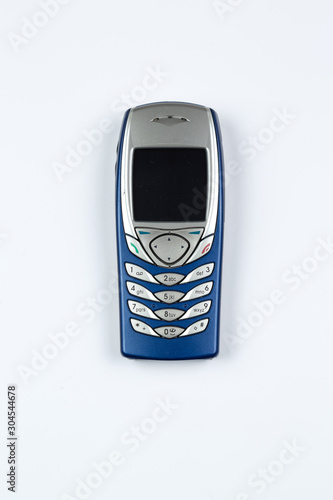 Photo of a used classic mobile phone, top view on white background. Perfect for use as cropped object.