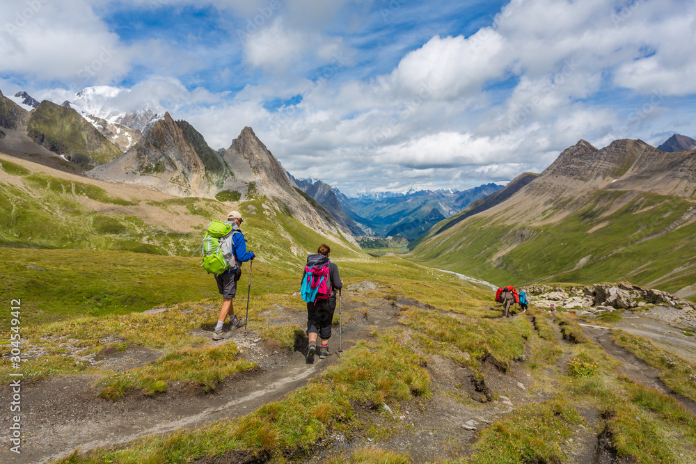 Couple de randonneurs marchant dans une vallée en montagne