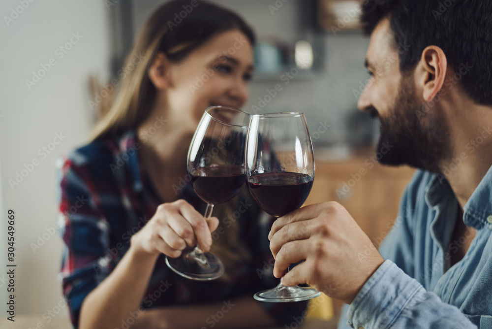  Close up of young couple toasting with wine at home
