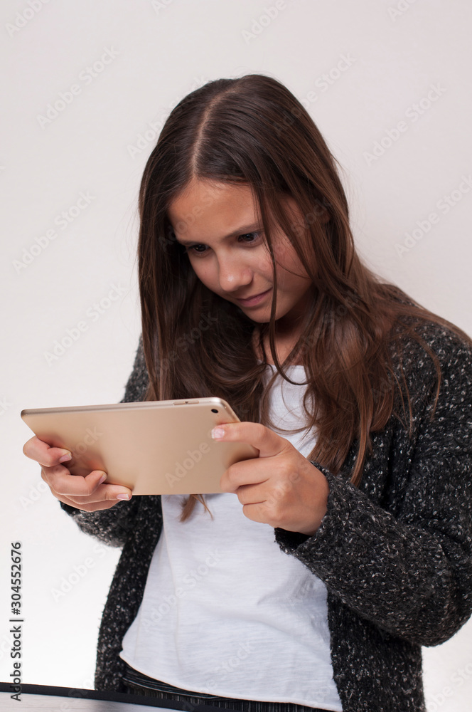 Young girl has the tablet in hand, she is looking at the tablet, Young girl has the tablet in hand, she is looking at the tablet,