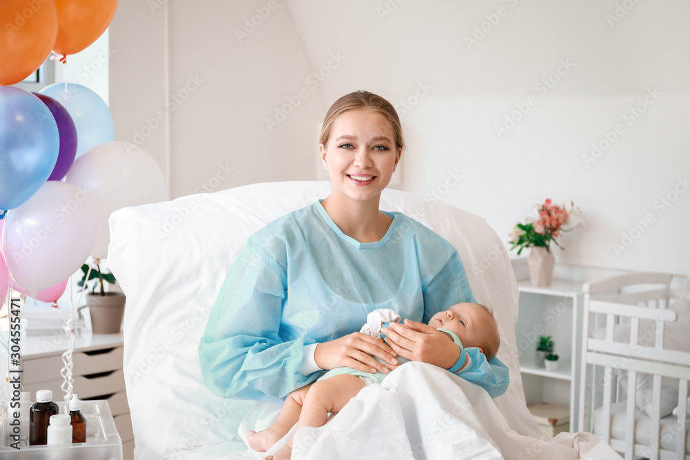 Fototapeta premium Young mother with newborn baby in maternity hospital