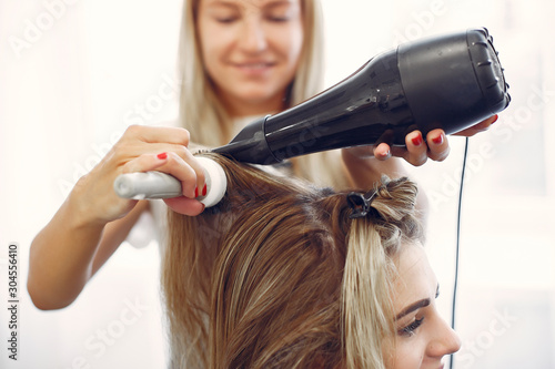 Hairdresser drying head her client. Woman in a hair salon