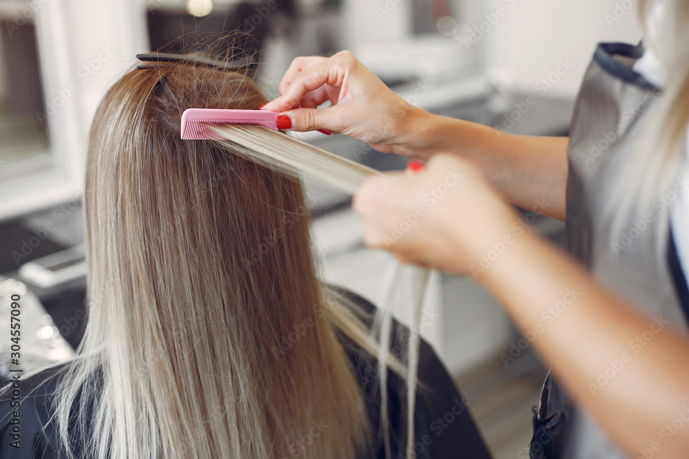 Hairdresser working with hear her client. Woman in a hair salon