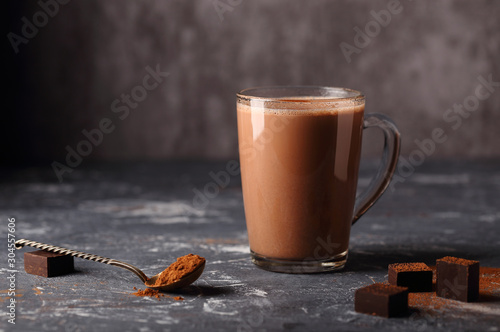 A delicious, natural cocoa drink with grated chocolate and milk in a glass mug is a source of vitamins and energy.