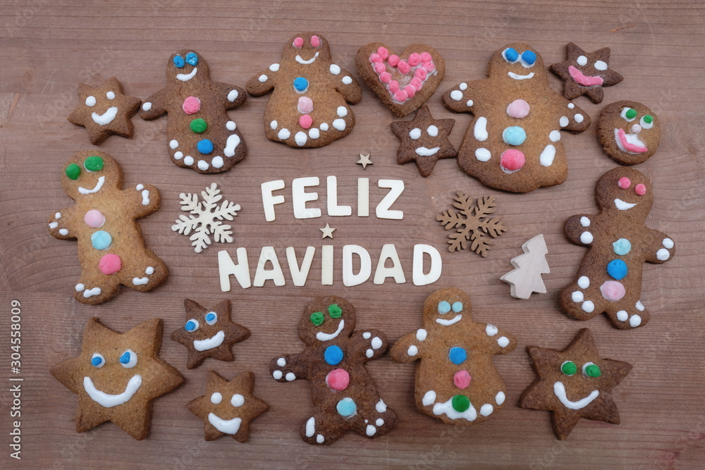 Feliz Navidad, spanish Merry Christmas message with gingerbread cookies and a creative text with wooden letters 