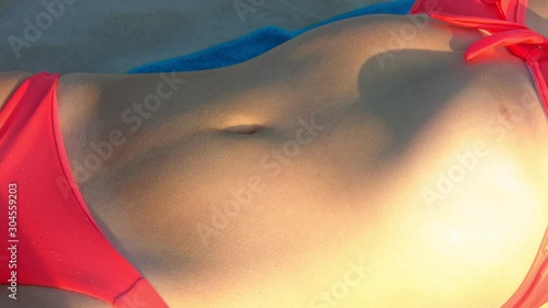 sunlight near sexy bellybutton of lying down lady photo