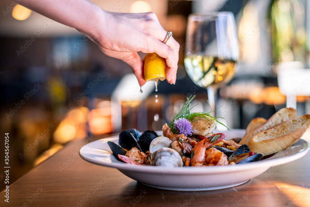 Bouillabaisse Seafood Soup Close-Up with Shrimp, Muscles, Clams, Fish, Fennel , Grilled Bread, and Wine