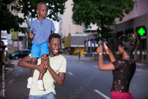 a young family with a mobile phone, smiling.