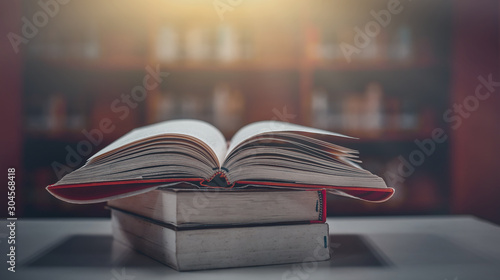 Stack of books in the library and blur bookshelf background photo