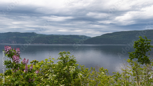 Smooth blue water under storm clouds at dusk in Saguenay Quebec