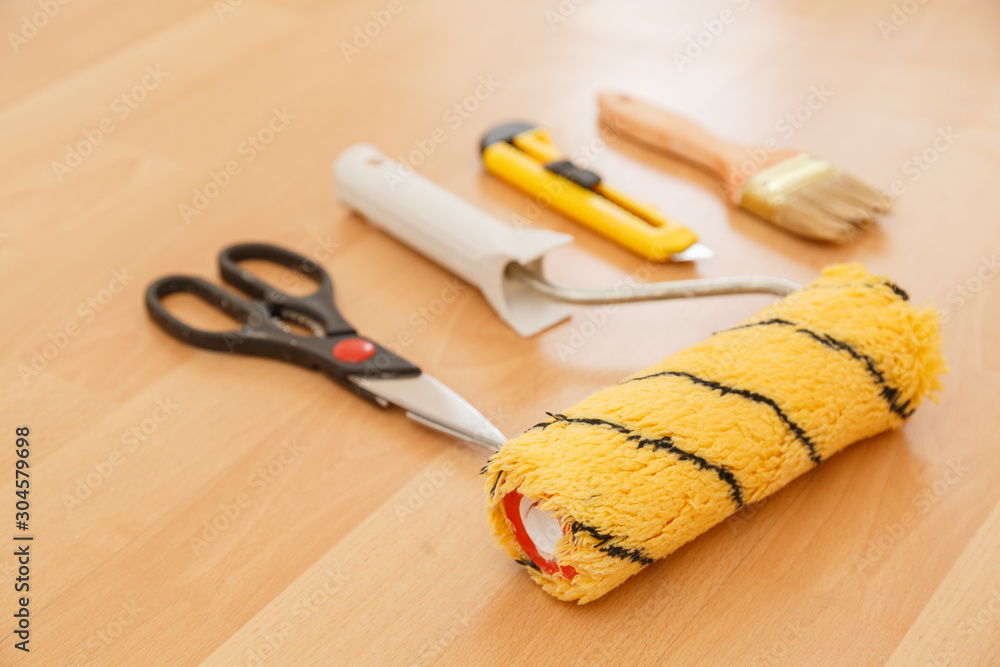 Tools for gluing wallpapers on the laminate floor. A room after renovation. Fresh repair in a room. Tools for gluing wallpapers on the laminate floor. A room after renovation. Fresh repair in a room.