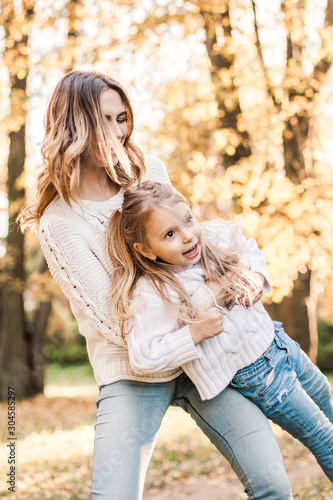 Happy daughter with mother is having fun walking in the park. © zadorozhna