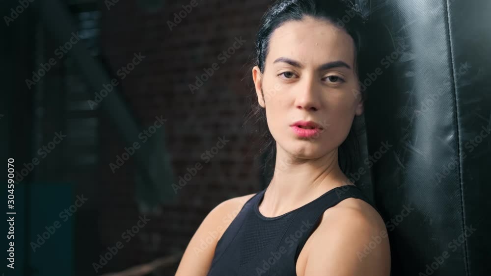 Close-up portrait of confident beautiful fighter Asian woman posing with punching bag zoom in Close-up portrait of confident beautiful fighter Asian woman posing with punching bag zoom in