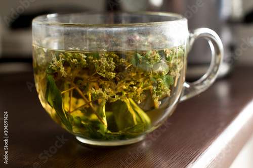 transparent mug with hot herbal mint tea in a kitchen