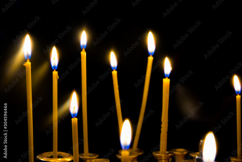 Fototapeta premium group of burning candles with dark background