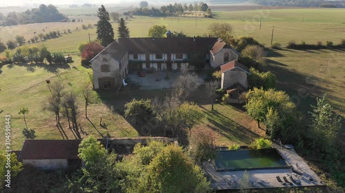 Aerial drone above a grand villa, farm and chateau at a green peaceful agricultural estate surrounded by green fields in Vesoul France. photo