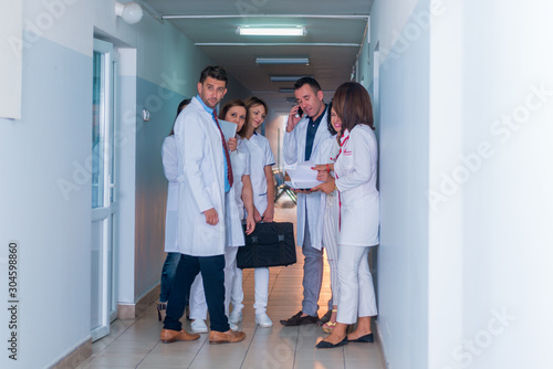 Group of medical staff  team doctors and nurses posing in the hallway of a hospital  clinic.